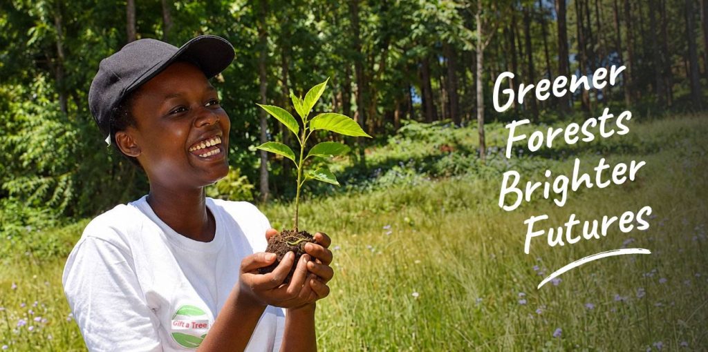 Woman holding a young tree at a Gift a Tree planting project in Tanzania